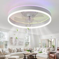 a living room with couches, chairs and a round light fixture in the ceiling