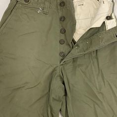 Vintage military work wear pants 1930-50s size: 28” inseam-31” Military Style Cotton Parachute Pants, Utility Full Length Pants With Button Closure, Fitted Military Cargo Pants, Cotton Cargo Pants With Buttons For Workwear, Khaki Cotton Cargo Pants With Button Closure, Khaki Wide Leg Pants With Button Closure, Fitted Military Cotton Bottoms, Military Style Straight Cargo Pants For Work, Fitted Military Style Cotton Bottoms