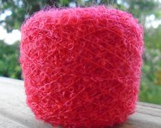 a roll of red yarn sitting on top of a wooden table