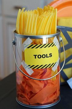 a bucket filled with lots of yellow and red pasta noodles on top of a table