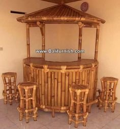 a bamboo hut with stools and tables in the corner on tile flooring next to wall