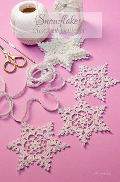 crocheted snowflakes and scissors on a pink surface