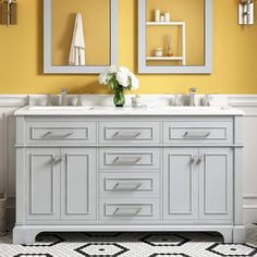 a bathroom with yellow walls and two mirrors on the wall next to it is a double sink