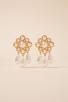 Featuring a gorgeous floral pattern with faux white pearls arranged in a cluster, these earrings are perfect for any formal occasion. The pearl tassels at the bottom add a playful and fun element to the design, making them a great choice for a night out with friends. SizeHeight: 2 in (5.08 cm)Width: 1.25 in (3.18 cm) QualityMade of metal alloy. Adorned with faux pearl clusters and teardrops. The post backings ensure a secure and comfortable fit, making these earrings suitable for all-day wear. I Elegant Dangle Clip-on Flower Earrings, Elegant Clip-on Dangle Flower Earrings, Elegant Clip-on Flower Earrings For Party, Formal Dangle Flower Earrings With Pearl Drop, Formal Pearl Drop Dangle Flower Earrings, Formal Pearl Drop Flower Dangle Earrings, Elegant Pearl Drop Flower Earrings For Party, Elegant White Clip-on Chandelier Earrings, Classic White Chandelier Earrings For Party