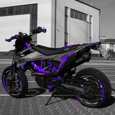 a purple and black motorcycle parked in front of a building