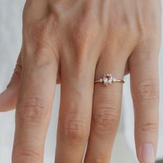 a woman's hand with a diamond ring on top of her finger and an engagement band