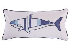 a blue and white pillow with a shark on it's side, in the shape of a fish