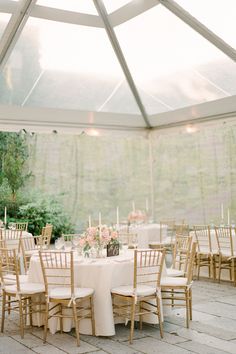 an outdoor tent with tables and chairs set up