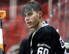 a young man holding a hockey stick in his hand