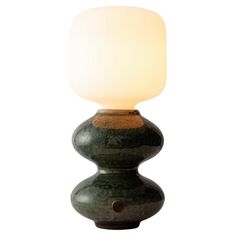 a green table lamp with a white light on it's top and bottom part