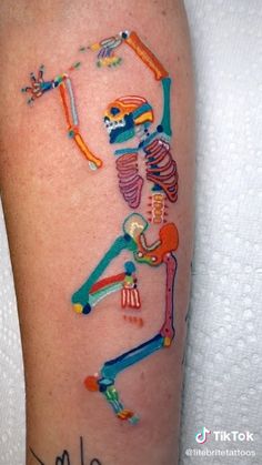 a colorful tattoo on the leg of a person with a baseball bat and skull in it