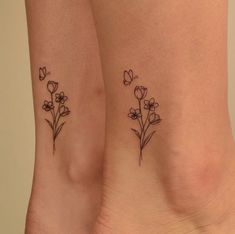 two small tattoos with flowers on their legs