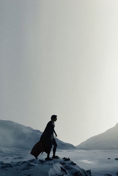 a man standing on top of a snow covered mountain