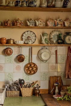 a kitchen filled with lots of pots and pans on top of a wooden shelf