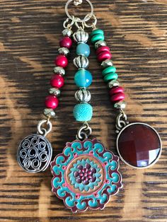 a necklace with several different charms hanging from it's sides on a wooden surface