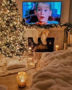 a living room with a christmas tree and television in the corner, surrounded by lights