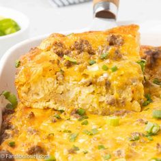 a casserole dish with meat, cheese and green onions in it on a plate