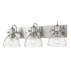 three light bathroom fixture with clear glass shades on the bottom and an old - fashioned metal finish