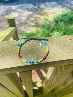 A serape, western blue, red, yellow, black, and white glass seed bead and wax string anklet complete with an adorable little feather charm. 🪶 Western Sunset, Black Sunset, Western Bracelets, Bracelet Inspo, Feather Charms, Bead Bracelets, Anklet Jewelry, Body Jewellery, Seed Bead