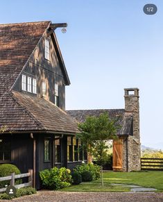 a black house with brown shingles on the roof