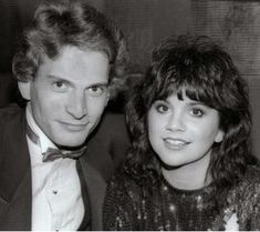 the man and woman are posing together for a photo in black and white, one is wearing a bow tie