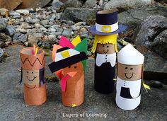 four toilet paper roll scarecrows are sitting on the ground