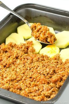 an apple crisp is being spooned into a casserole dish