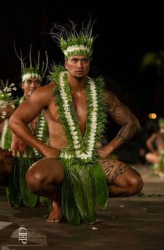 a man in hula skirt kneeling down with his hands on his hips