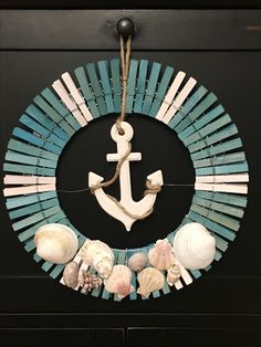 a wreath with an anchor and seashells hangs on the door to decorate it