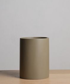 a grey vase sitting on top of a wooden table