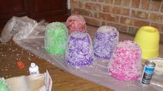 there are many different colored candy cones on the floor next to a brick wall with plastic wrap around them