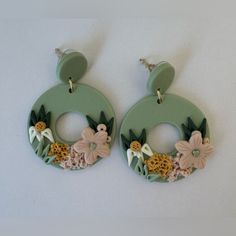 the earrings are decorated with flowers and leaves