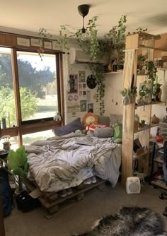 a bed room with a neatly made bed and lots of plants on the wall next to it