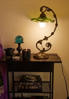 a table with a lamp on top of it next to a vase and other items