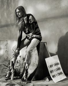 a black and white photo of a woman sitting on a rock with a sign that says i'm my china, my own