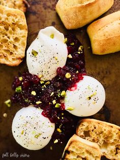 an assortment of breads and cranberry sauce on a baking sheet with other food items