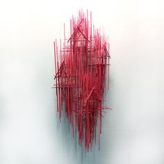 a red sculpture is shown against a white wall