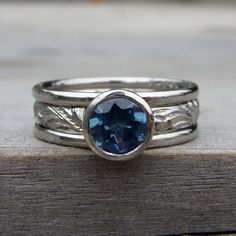 a ring with a blue stone in it on top of a wooden table next to the words fabulous jewelry