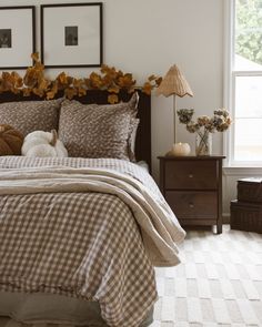 a bed with two teddy bears sitting on it's headboard in front of a window