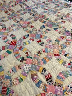 an old quilt is laying on top of a tablecloth that has been turned into a bed spread