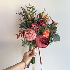 a person holding a bouquet of flowers in their hand