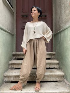 a woman standing on steps in front of a door with her hands on her hips