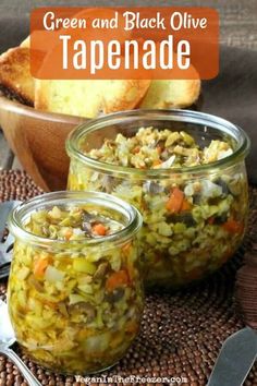 green and black olive tapenade in glass jars with spoons next to it