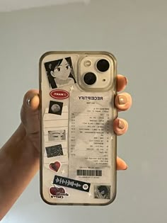 a person holding up a cell phone case with pictures and words on the back cover