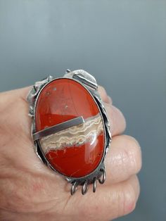 "Lovely hand made oxidized sterling silver + banded agate stone fantasy ring.  You will get this ring. Banded agate is a unique variety of chalcedony, a mineral in the quartz family. Banded agate has been valued for its beauty and spiritual properties for thousands of years. In ancient times, it was believed to have protective powers and was often used as a talisman to ward off evil and promote good luck. It was also believed to have healing properties, particularly for digestive and skin disord Unique Jasper Ring Jewelry, Unique Jasper Rings For Gift, Unique Collectible Rings With Natural Stones, Bohemian Agate Ring With Large Stone, Unique Carnelian Ring Jewelry, Unique Agate Rings With Natural Stones, Handmade Silver Jasper Rings, Unique Silver Carnelian Rings, Unique Carnelian Jewelry With Large Stone