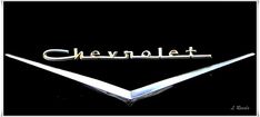 the chevrolet logo is shown in this black and white photo, with gold lettering on it