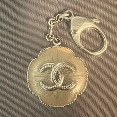 Such A Rare Find! A Large Authentic Chanel Bag Charm From The Camellia Line. It Is Difficult To Find These Enamel Keychains Great Condition With Just A Little Discoloration On The Top Right. Beige Into Gold Color, Would Bring A Lot Of Style To Your Tote! 1.5” For The Medallion, 4” In Length. Silver Tone Metal. Enamel Keychains, Camellia Chanel, Chanel Accessories, Charm Keychain, Key Card Holder, Beige Color, Chanel Bag, Keychains, Gold Color