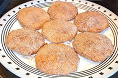 a white plate topped with cookies covered in powdered sugar on top of a stove