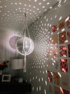 a lamp hanging from the ceiling in front of a wall with pictures and lights on it