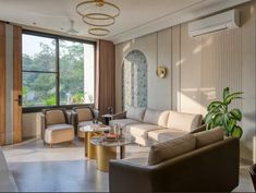 a living room with couches, chairs and tables in front of a large window